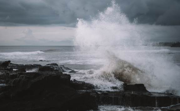 Waves crash aggressively into the coastline